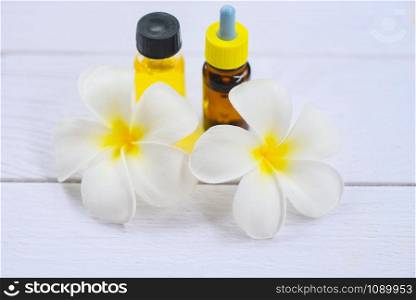 Aromatherapy herbal oil bottles aroma with white flower Frangipani Plumeriaon / Essential oils natural on wooden table and organic minimalist