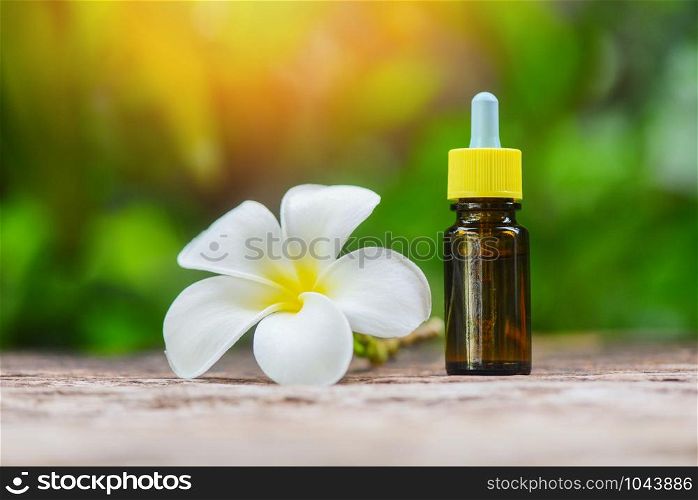 Aromatherapy herbal oil bottles aroma with white flower Frangipani Plumeriaon on nature green / Essential oils natural for face and body beauty remedies on wooden table and organic minimalist