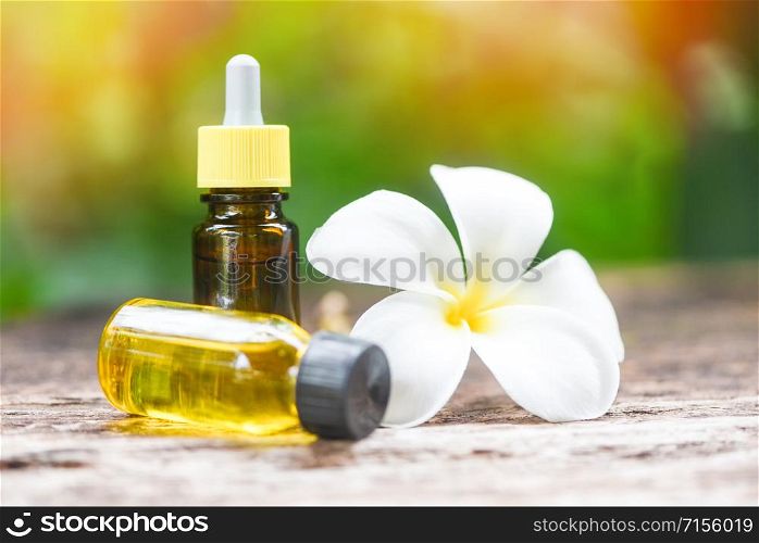 Aromatherapy herbal oil bottles aroma with white flower Frangipani Plumeriaon with nature background / Essential oils natural on wooden table and organic minimalist spa