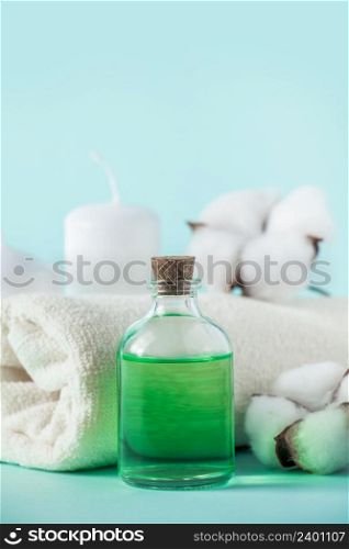 Aromatherapy wellness concept. Spa and relaxation accessories on a blue background. Aromatic oil, towel, candle and flowers. Organic skin care product.. Aromatherapy wellness concept. Spa and relaxation accessories on blue background. Aromatic oil, towel, candle and flowers. Organic skin care product.