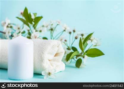 Aromatherapy wellness concept. Spa and relaxation accessories on a blue background. Aromatic oil, towel, candle and flowers. Organic skin care product.. Aromatherapy wellness concept. Spa and relaxation accessories on blue background. Aromatic oil, towel, candle and flowers. Organic skin care product.
