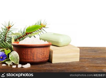 Aromatic bath salt in a clay cup and soap on a wooden background