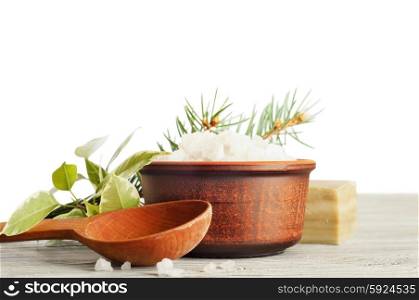 Aromatic bath salt in a clay cup and wooden spoon