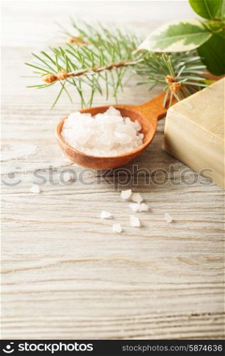 Aromatic bath salt in a wooden spoon, pine branch and soap