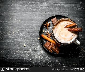 Aromatic cocoa drink with cinnamon and chocolate. On black rustic background. Aromatic cocoa drink with cinnamon and chocolate.