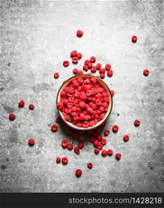 Aromatic raspberries in a bowl. On a stone background.. Aromatic raspberries in a bowl.