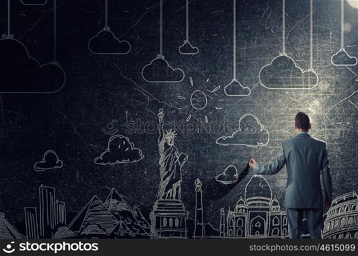 Around the world concept. Back view of businessman drawing on wall concept of traveling