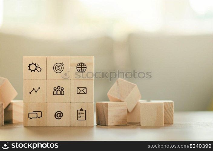 Arrange overlapping wooden blocks with business leaders icons. Key success factors include the world, thought box, inbox, email, internet, goals, preferences, people, business, and statistical graphs.
