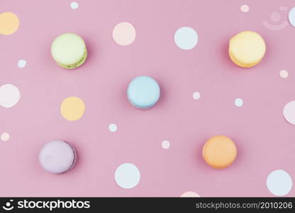 arranged colorful macaroons with confetti top view