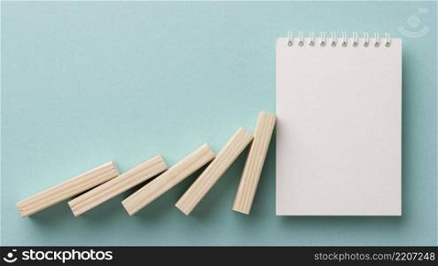 arrangement financial crisis with wooden pieces blank notepad