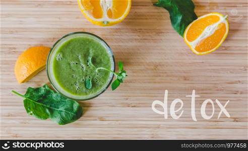 Arrangement of a fresh green healthy smoothie and fruits on a wooden background. ?detox?