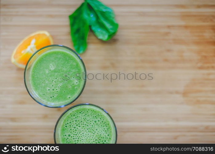 Arrangement of a fresh green healthy smoothies and fruits on a wooden background. Text space.