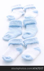 Arrangement of three pairs of blue infant boy socks for baby shower