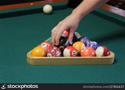 Arranging the balls on the pool table to get ready to play