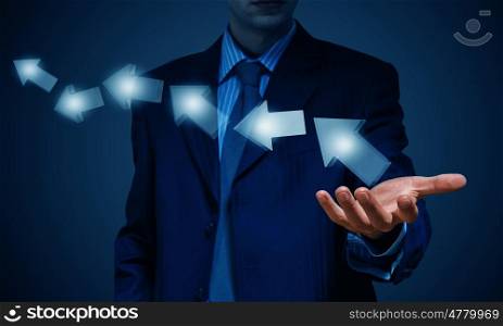Arrow icons as growth concept. Businessman holding arrows in palm over dark background