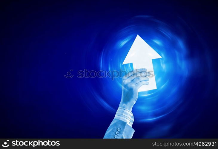 Arrow in hand. Businessman hand with digital arrow icon on blue background