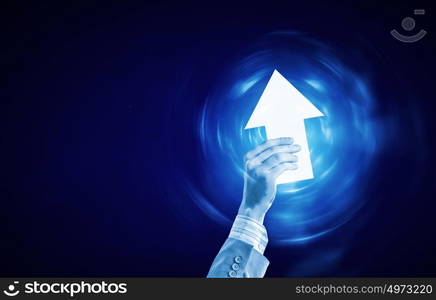 Arrow in hand. Businessman hand with digital arrow icon on blue background