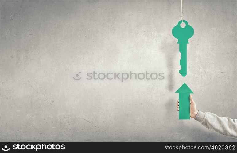 Arrow in hand. Hand of businessman holding green arrow and pointing at key