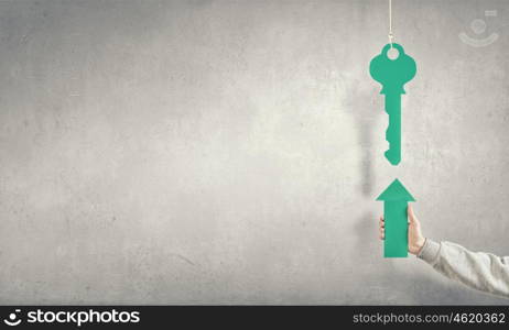 Arrow in hand. Hand of businessman holding green arrow and pointing at key