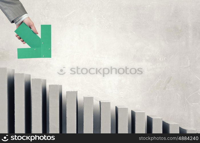 Arrow in hand. Hand of businessman holding green arrow pointing direction