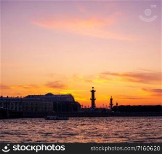 Arrow of Vasilyevsky Island on a background of orange sunset. Vasilievsky island at sunset