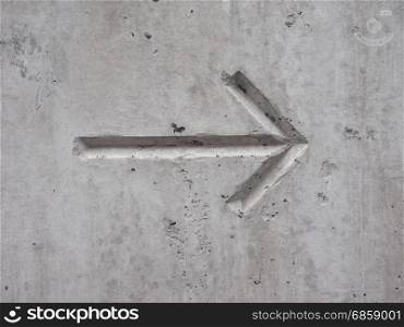 arrow on concrete. left to right direction arrow on concrete wall background