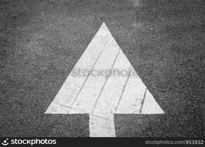 Arrow symbol traffic on the road asphalt. Sign of further progress.