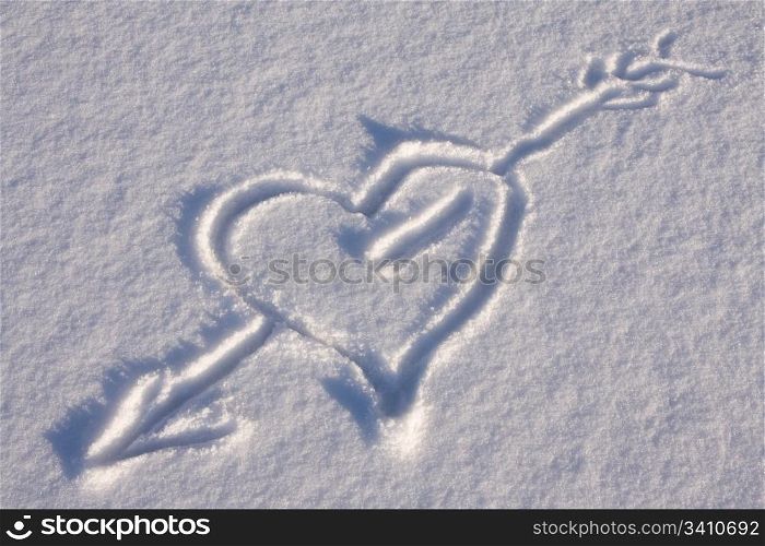 Arrow through a heart on the snow