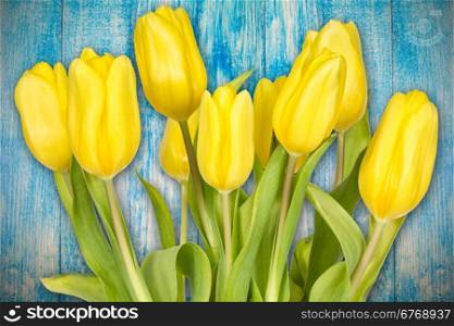 Art abstract background with spring tulips on wooden surface