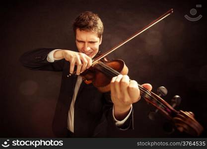 Art and artist. Young elegant man emotional violinist fiddler playing violin on black. Classical music. Studio shot.