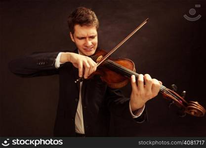 Art and artist. Young elegant man emotional violinist fiddler playing violin on black. Classical music. Studio shot.