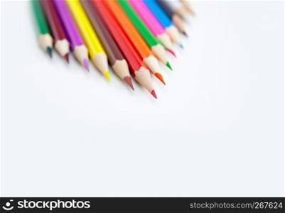 Art and drawing creativity concepts of colored crayon pencils on white background aligned with triangle shape at the corner with copy space. Top view, Close-up, For banner design.