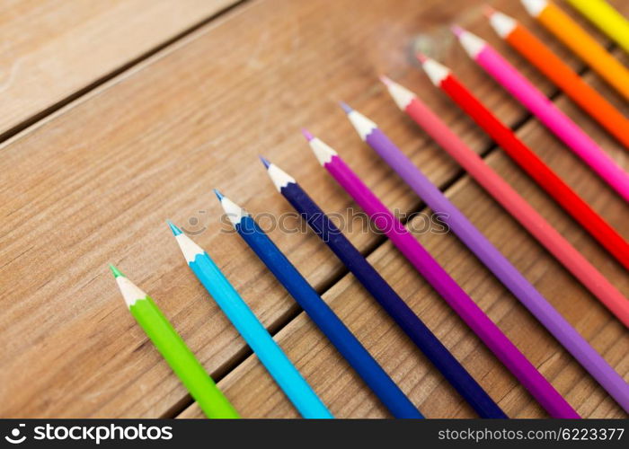 art, color, drawing, creativity and object concept - close up of crayons or color pencils on wooden table