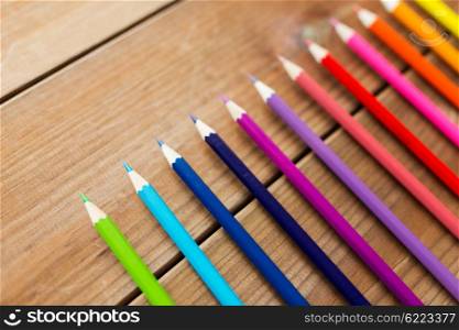 art, color, drawing, creativity and object concept - close up of crayons or color pencils on wooden table