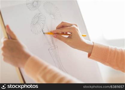 art, creativity and people concept - artist hands with graphite pencil drawing still life picture of flower in vase on paper at studio. artist with pencil drawing picture at art studio