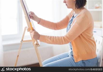 art, creativity and people concept - artist with eraser and easel at studio. artist with eraser and easel at studio