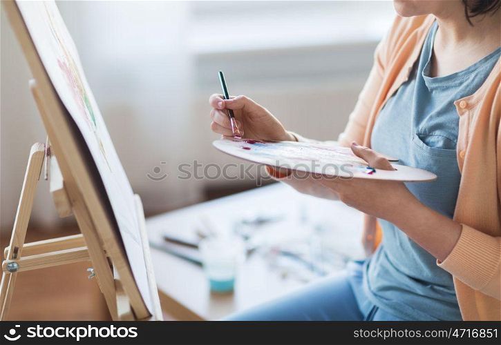 art, creativity and people concept - close up of artist with palette and brush painting still life on paper at studio. artist with palette and brush painting at studio. artist with palette and brush painting at studio