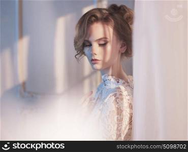 Art fashion photo of beautiful gorgeous woman in lace dress at the window. Beauty and health. Wedding style. Bridal morning