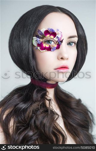 Art fashion portrait of beautiful woman with bright makeup decorated with flowers. Fantasy girl portrait. Summer fairy portrait. Long hair