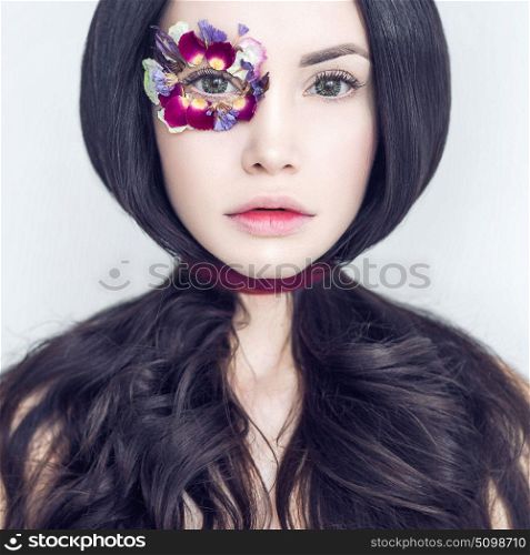 Art fashion portrait of beautiful woman with bright makeup decorated with flowers. Fantasy girl portrait. Summer fairy portrait. Long hair