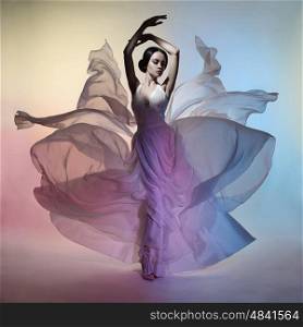 Art fashion studio photo of beautiful elegant woman in blowing dress. Flying dress. Freedom concept&#xA;Drawing of colors. Light and color effects. Fashion style of flowing dress
