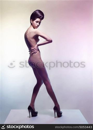Art fashion studio photo of nude elegant woman on a colored pastel background. Perfect body. Beauty and health