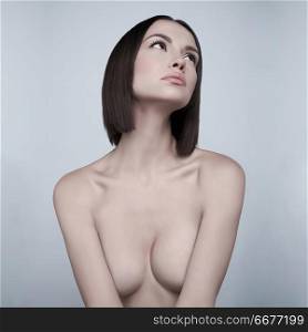 Art fashion studio portrait of beautiful brunette with short haircut. Young sexy model pose in white studio with naked body. Nude lady with classic professional make-up