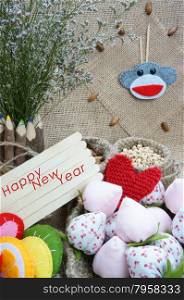 Art idea with funny monkey for happy new year 2016, new year eve time, handmade monkey face, clockwise, colorful hand made fruit, fibre strawberry, flower decor on burlap background, vintage concept