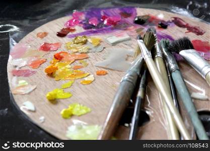 art materials, artists paint brushes on wooden palette