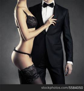 Art photo of a young couple in sensual lingerie and a tuxedo
