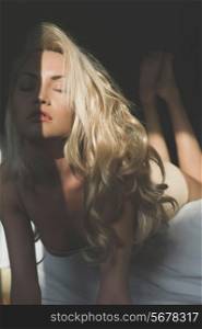 Art photo of beautiful blonde in bed in the sun