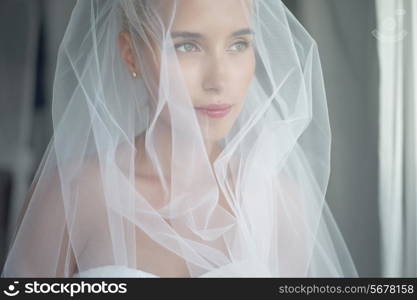 Art photo of beautiful bride waiting at the window