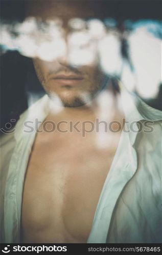 Art portrait of an attractive man through the window