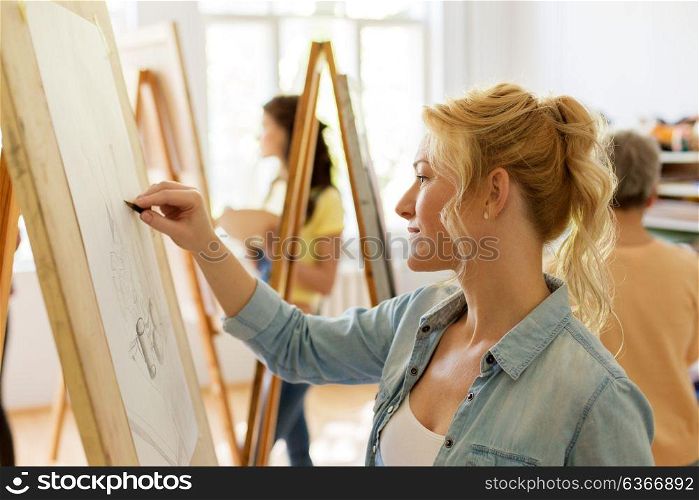 art school, creativity and people concept - woman with easel drawing at studio. woman with easel drawing at art school studio